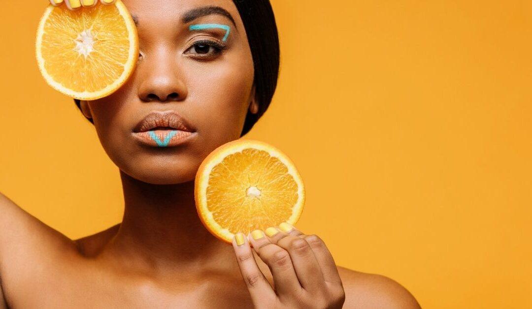 Woman holding fresh orange slices representing vitamin C skincare