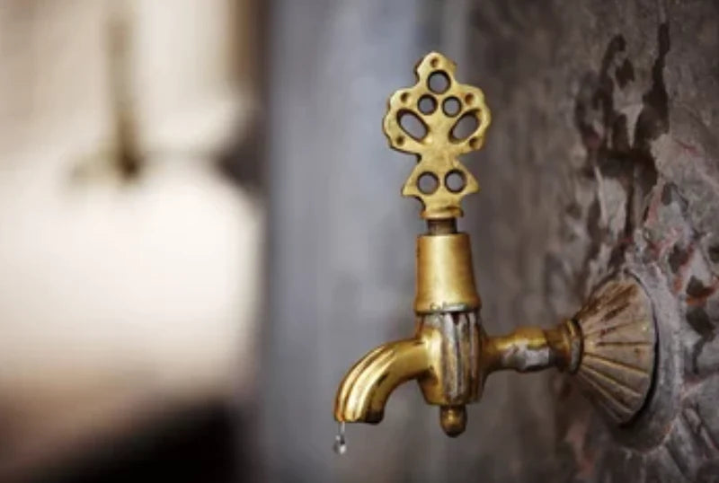 Brass wudu tap with running water, the ablution ritual before a post-wudu skincare routine